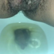 From under the toilet, a very cute girl pushes out a hanging log that drops, then pisses over the product. Filmed from a between the legs perspective. Vertical format video. About a minute.